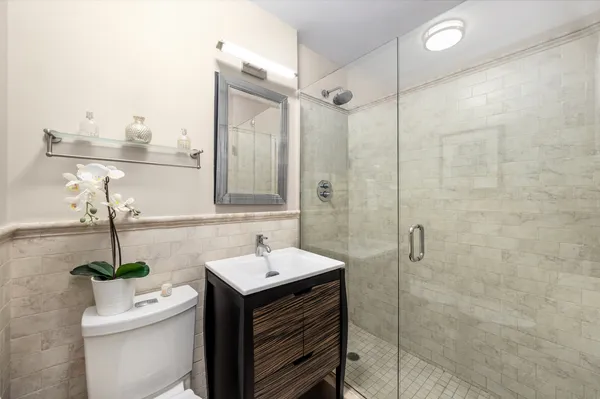 a bathroom with a sink a toilet and shower
