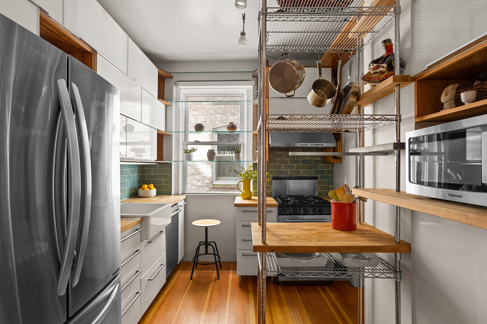 34-43 82nd Street, Unit 22 Queens, NY 11372 - Photo 3 of 11 a kitchen with stainless steel appliances a stove a refrigerator and wooden floor