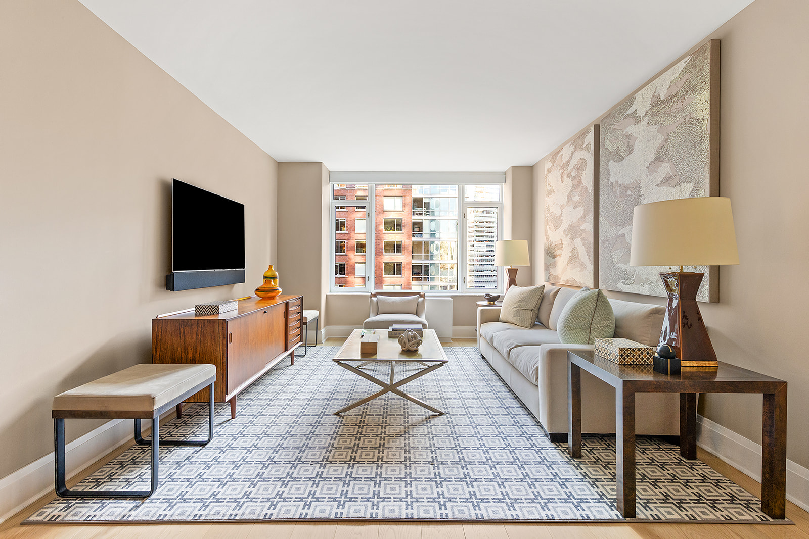 210 Warren Street, Unit 10G Manhattan, NY 10282 - Photo 2 of 15 a living room with furniture a rug and a flat screen tv