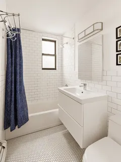 a bathroom with a sink a toilet a mirror and shower