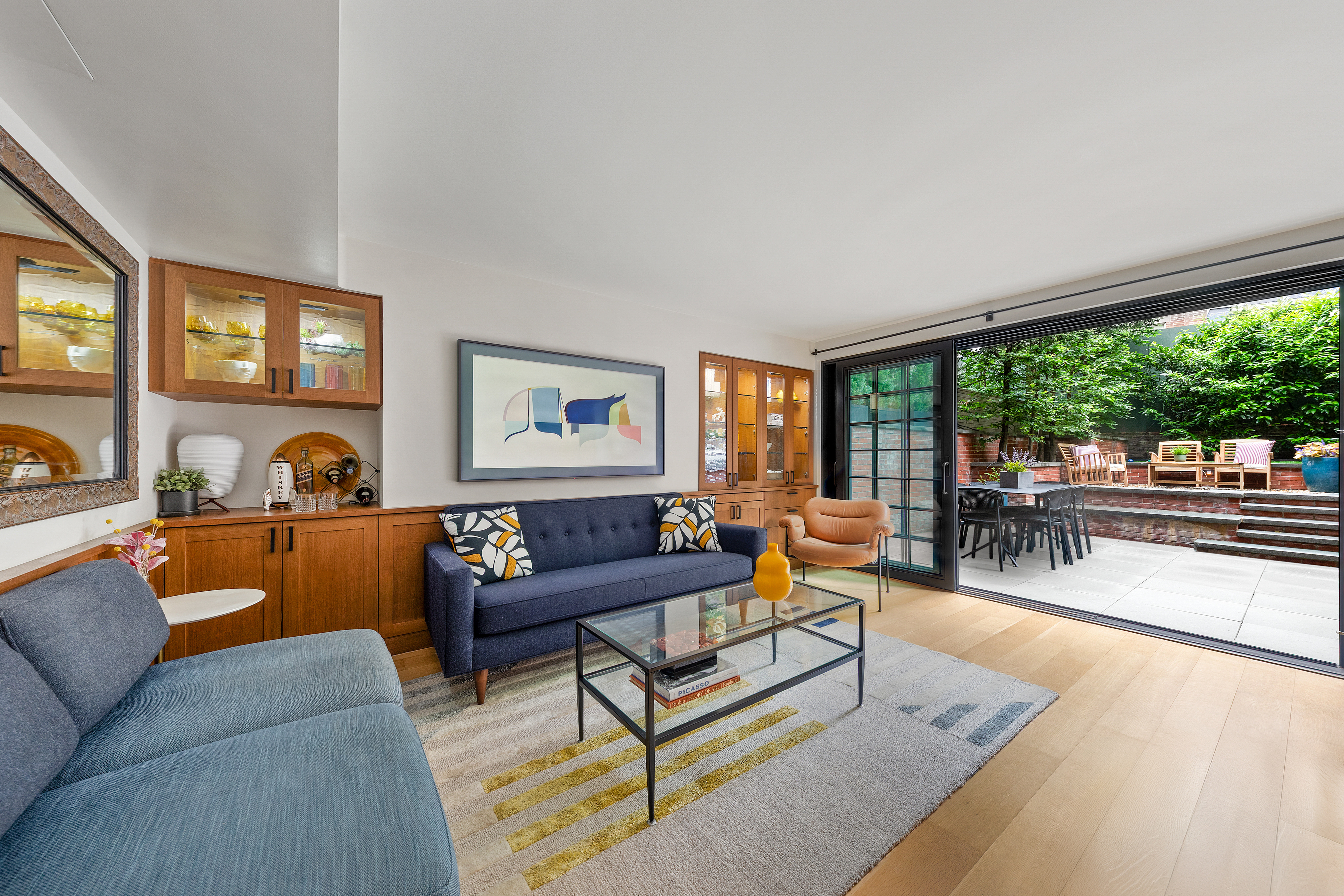 21 Bethune Street, Unit GARDEN Manhattan, NY 10014 - Photo 2 of 12 a living room with furniture and a floor to ceiling window