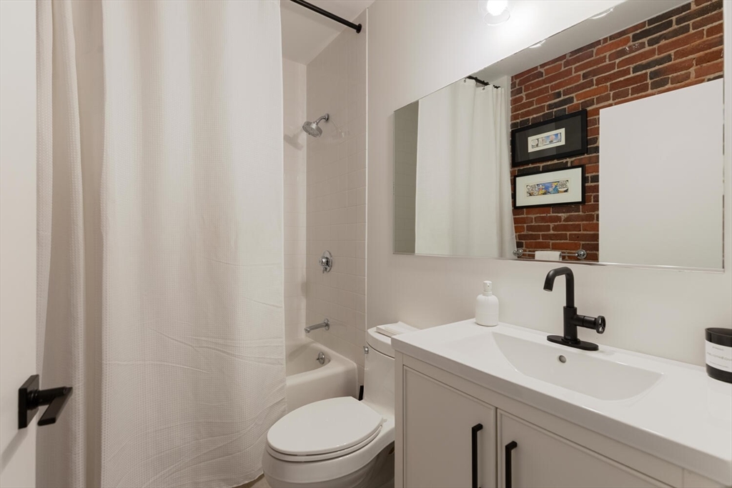 35 Channel Center Street, Unit 402 Boston, MA 02210 - Photo 24 of 35 a bathroom with a toilet a sink and mirror