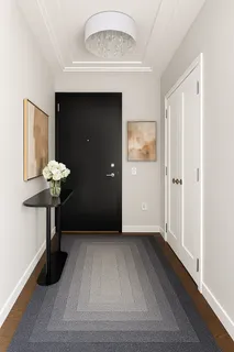 a view of a hallway with wooden floor and a chandelier