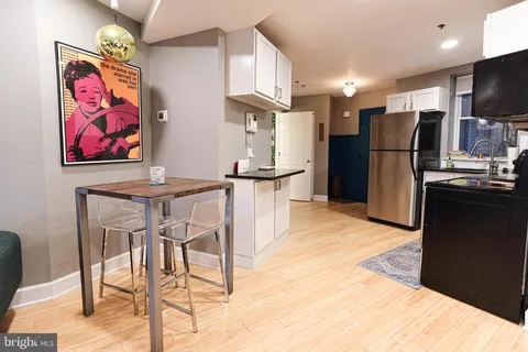 a kitchen with stainless steel appliances kitchen island granite countertop a refrigerator and a stove top oven with wooden floor