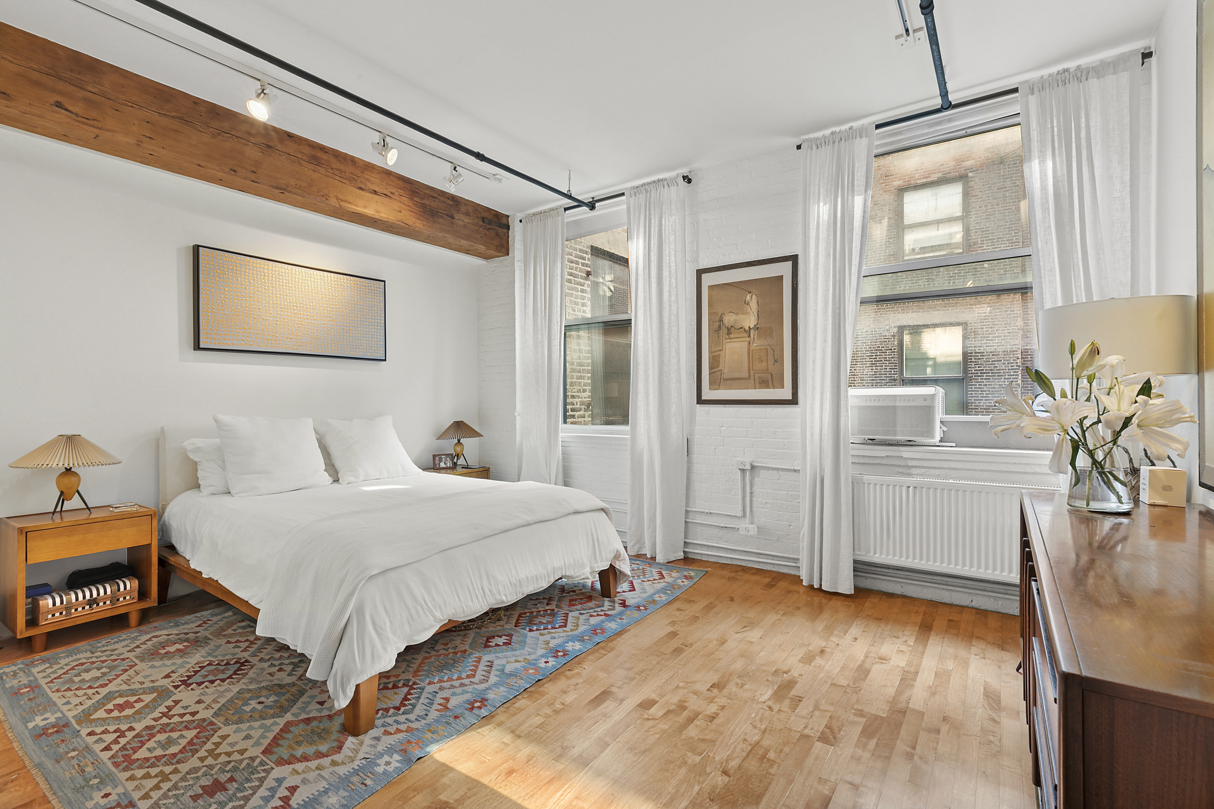 108 Wooster Street, Unit 4C Manhattan, NY 10012 - Photo 5 of 9 a bedroom with a bed and a flat screen tv