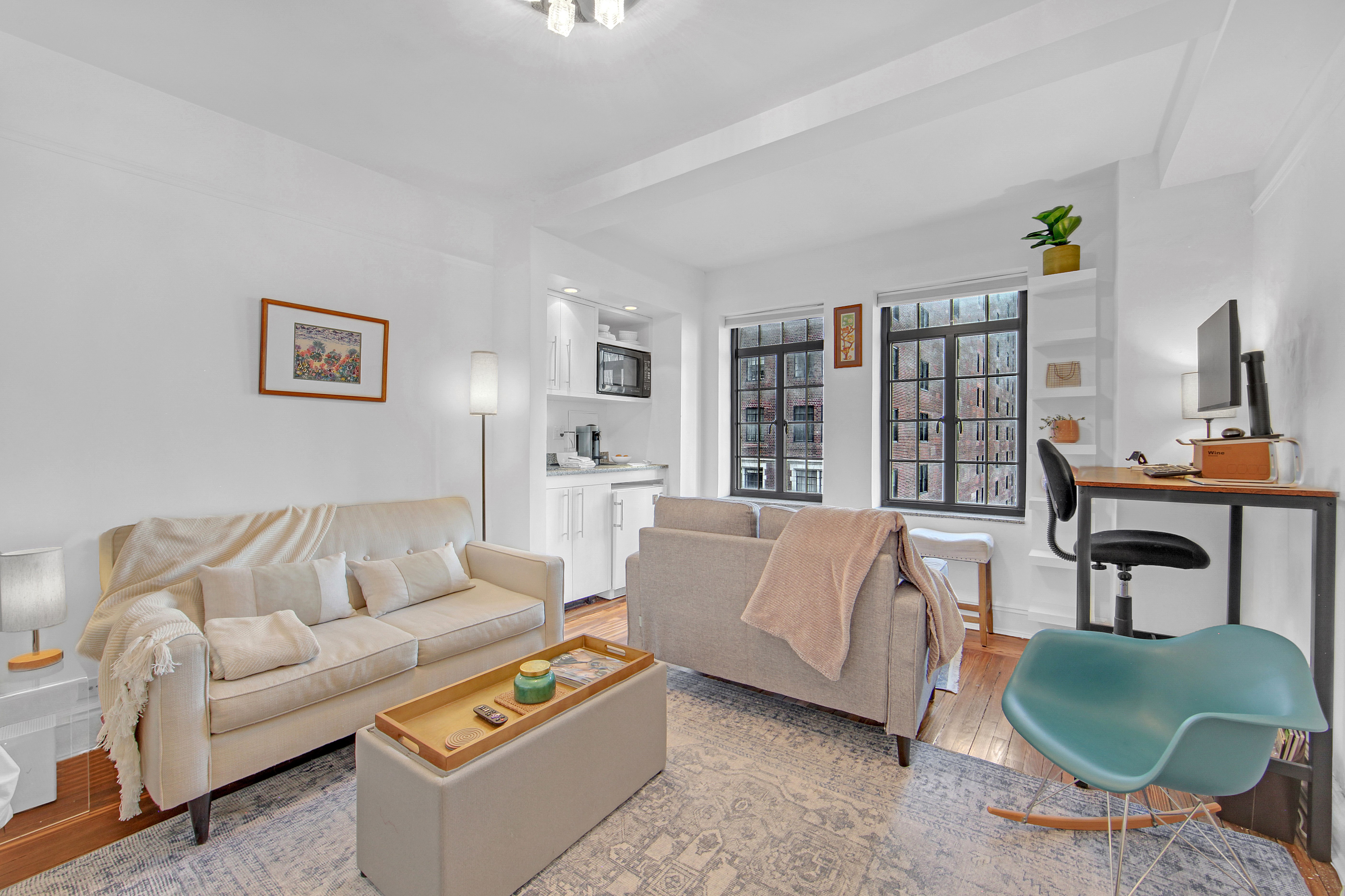 5 Tudor City Place, Unit 539 Manhattan, NY 10017 - Photo 2 of 12 a living room with furniture and a potted plant