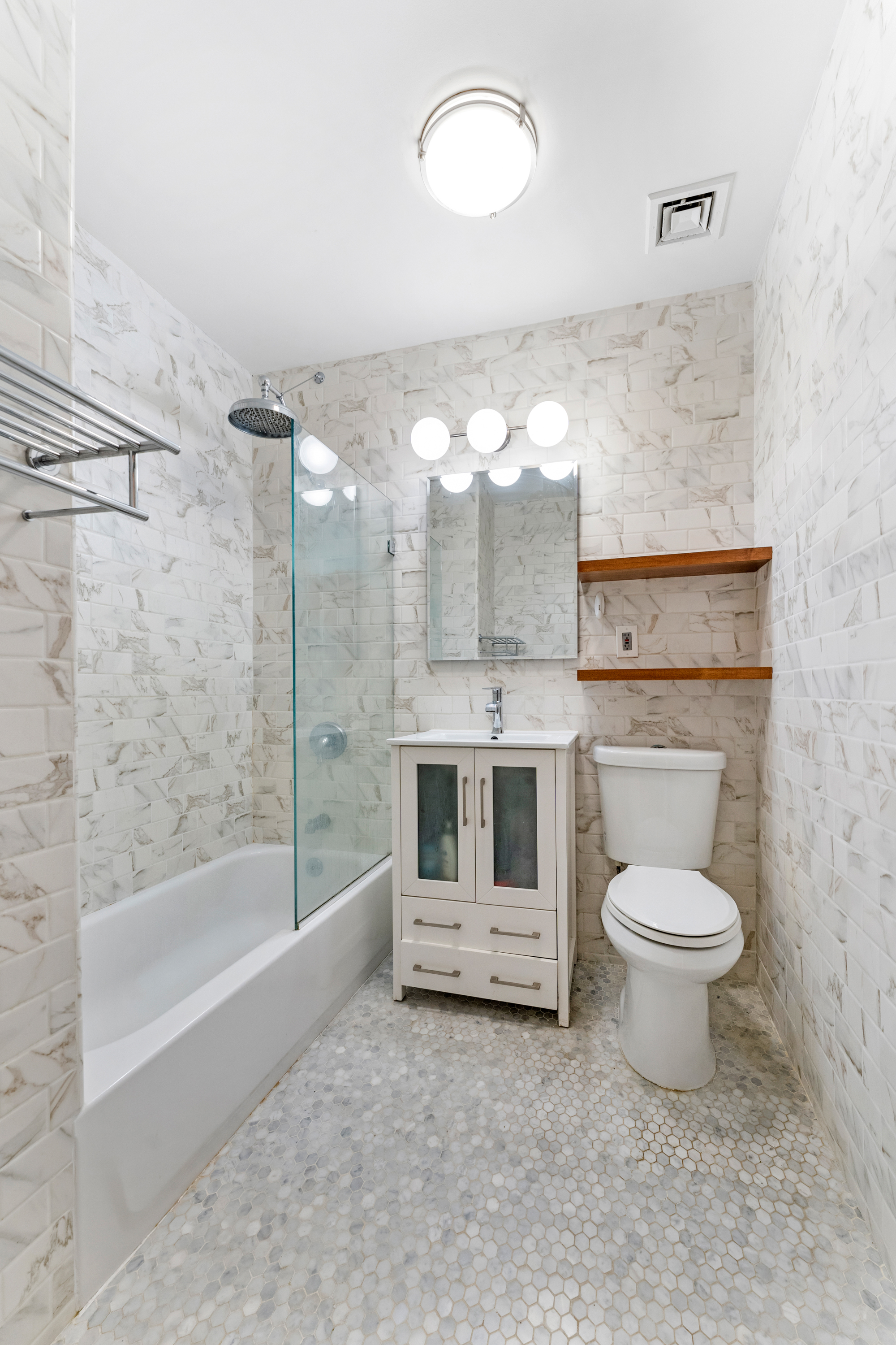 315 7th Avenue, Unit 5C Manhattan, NY 10001 - Photo 6 of 7 a bathroom with a sink a toilet and bathtub