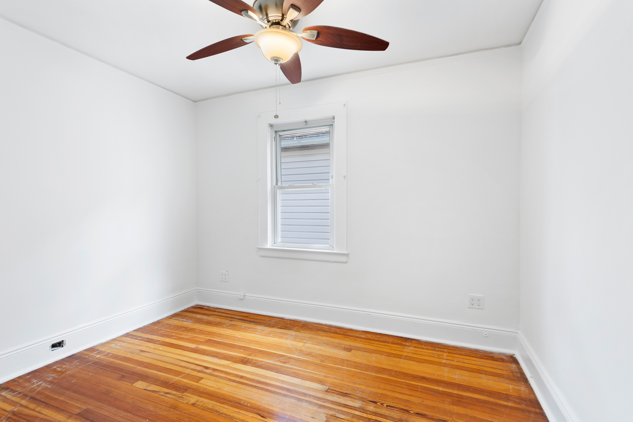 91-22 92nd Street Queens, NY 11421 - Photo 11 of 27 an empty room with a window and wooden floor