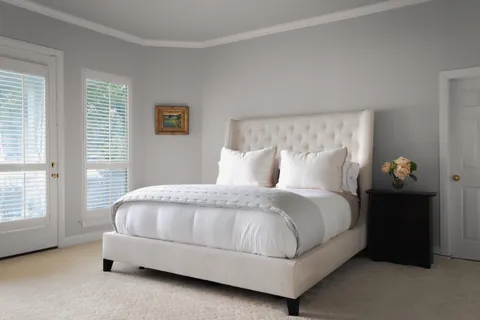 a large bed sitting in a bedroom next to a window and a couch