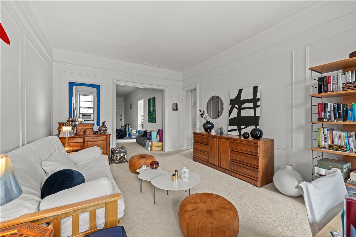 a living room with furniture a rug and a book shelf