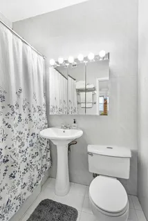 a bathroom with a sink a toilet and mirror