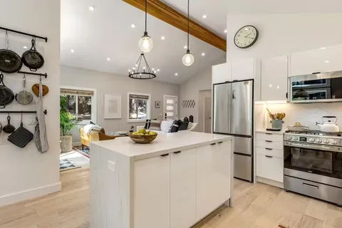 a kitchen that has a lot of stainless steel appliances and cabinets