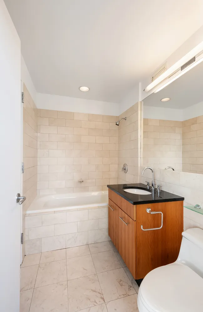 11 East 29th Street, Unit 28B Manhattan, NY 10016 - Photo 6 of 9 a bathroom with a granite countertop toilet a sink and bathtub