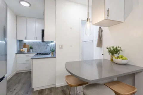 a kitchen with stainless steel appliances a table and chairs