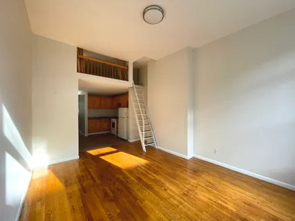 a view of a room with wooden floor and bedroom
