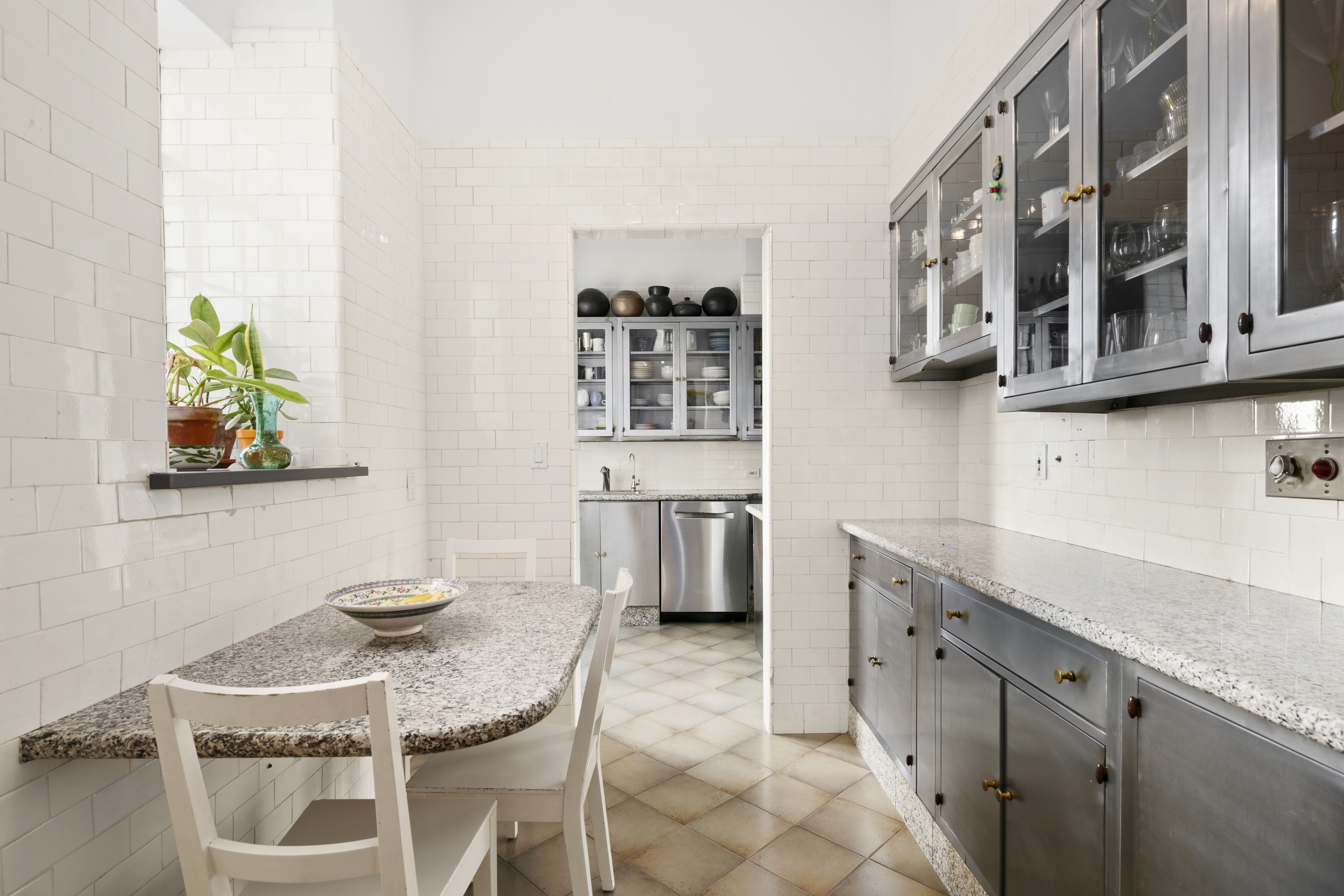 300 Central Park West, Unit 21G Manhattan, NY 10024 - Photo 10 of 21 a kitchen with stainless steel appliances kitchen island granite countertop a table and chairs in it