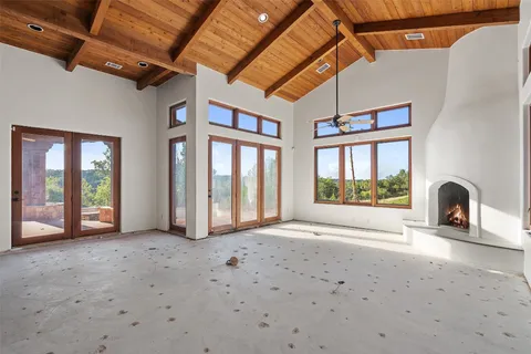 a view of an empty room with a fireplace and a window