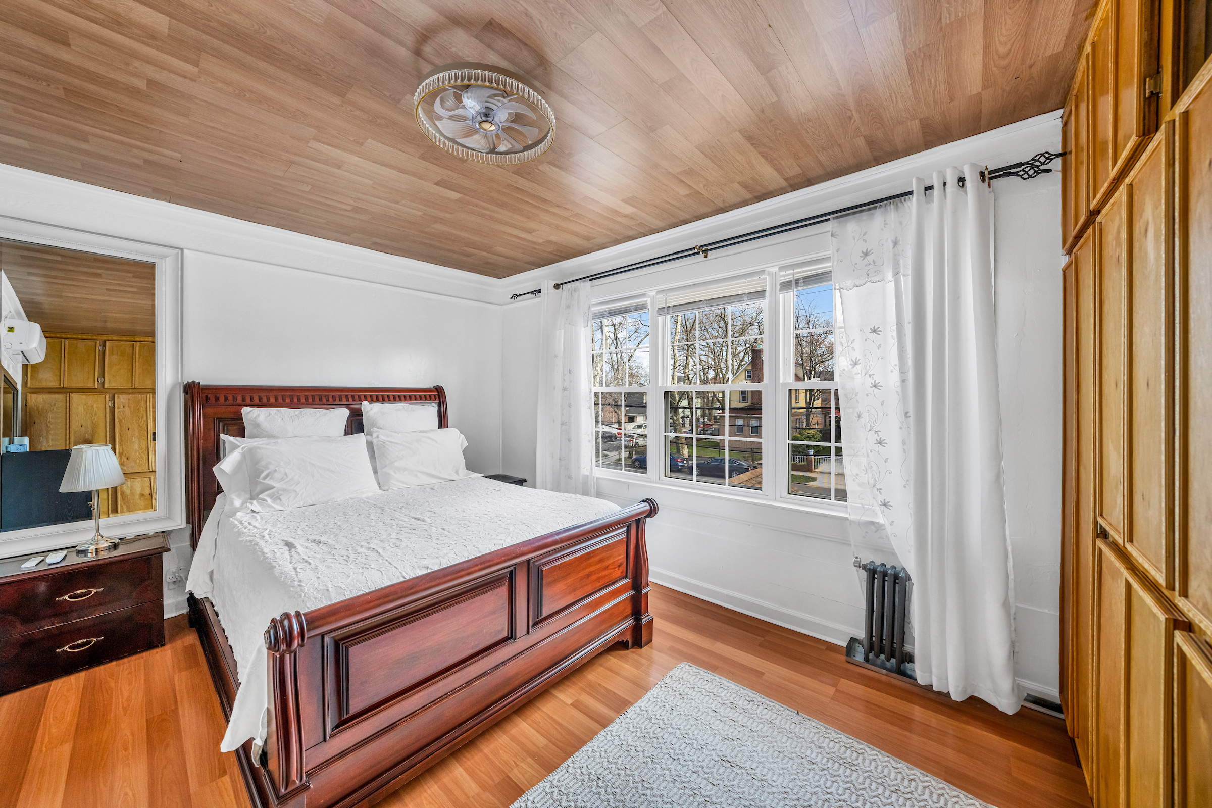 132-11 107th Avenue Queens, NY 11419 - Photo 6 of 14 a bed sitting in a bedroom next to a window