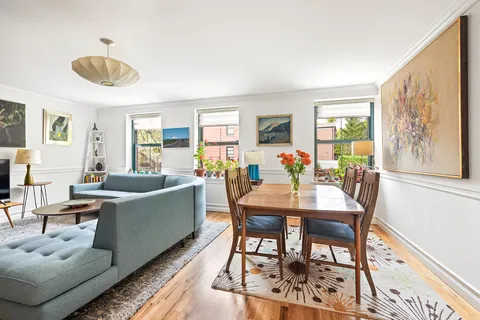 a living room with furniture a large window and a dining table