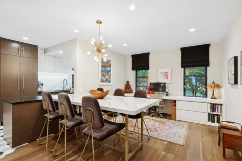 a view of a dining room with furniture and a chandelier