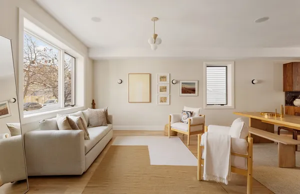 a living room with furniture wooden floor and a large window