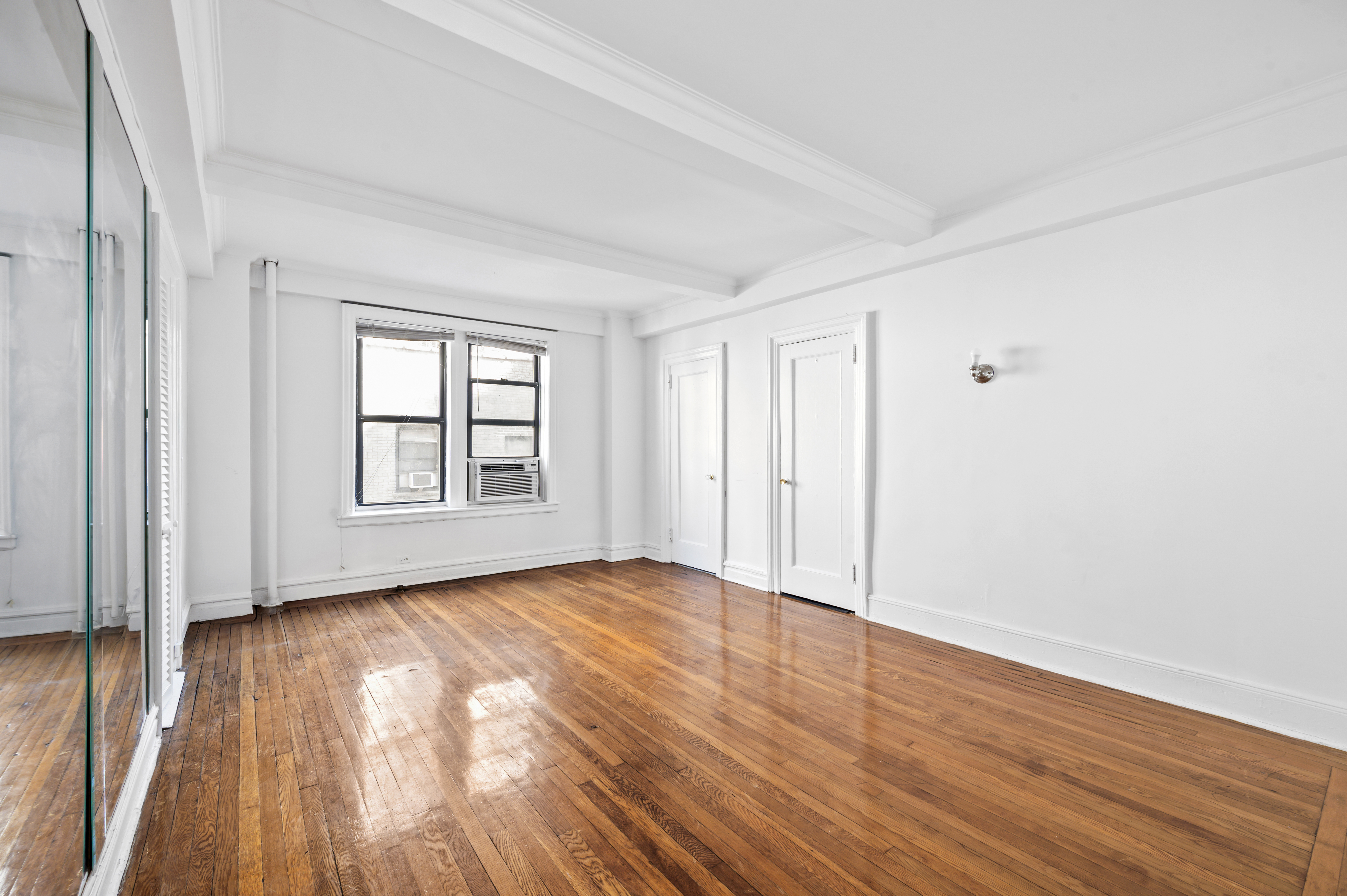 17 West 64th Street, Unit 6E Manhattan, NY 10023 - Photo 1 of 6 a view of an empty room with wooden floor and a window