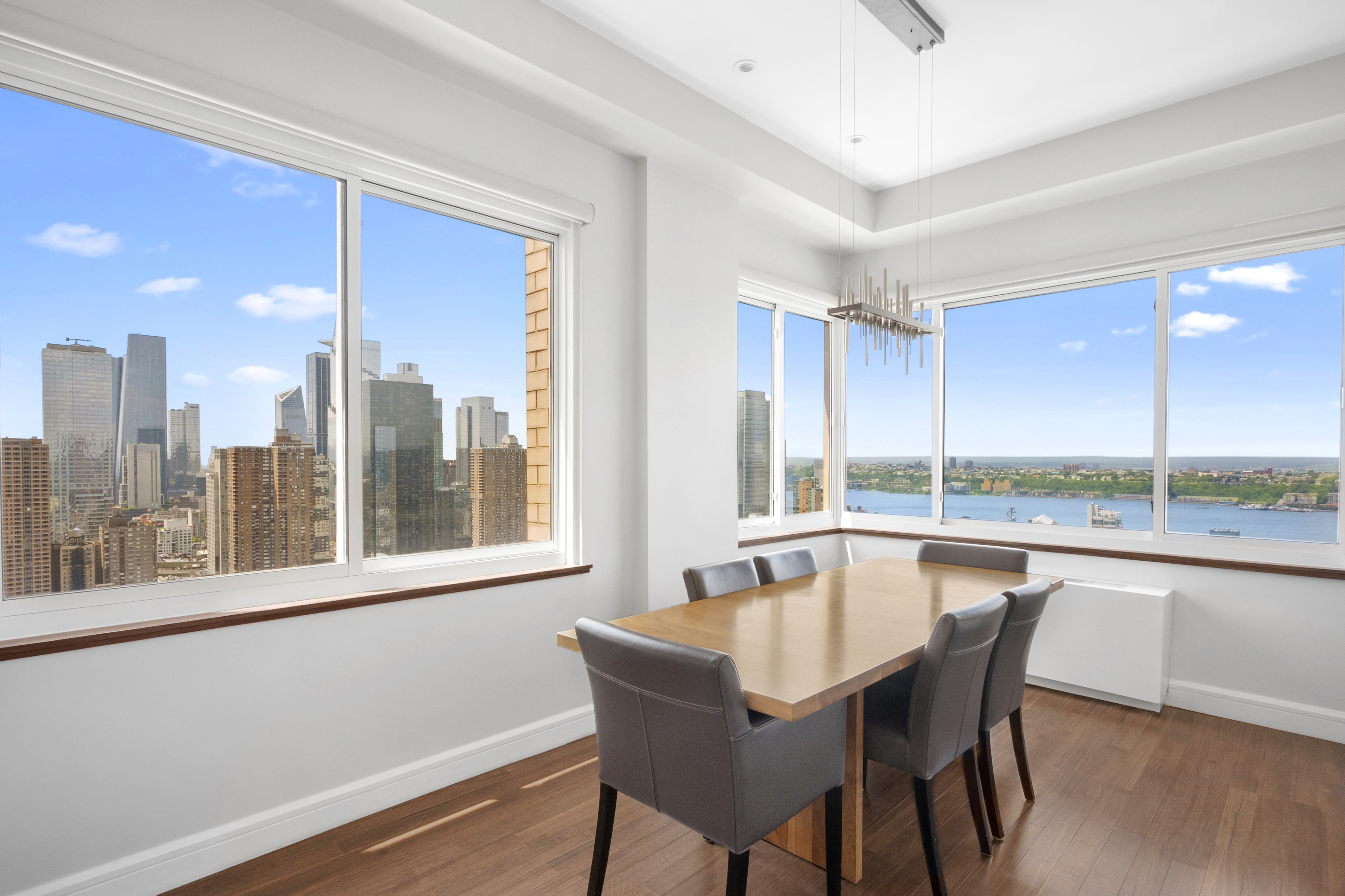 350 West 50th Street, Unit PH4B Manhattan, NY 10019 - Photo 3 of 18 a dining room with furniture a chandelier and wooden floor
