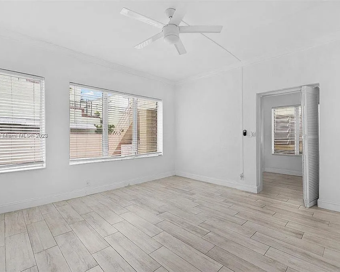 2822 Pine Tree Drive Miami Beach, FL 33140 - Photo 9 of 21 a view of an empty room with a window and wooden floor
