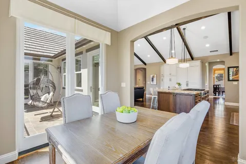 a view of a dining room with furniture a chandelier and wooden floor