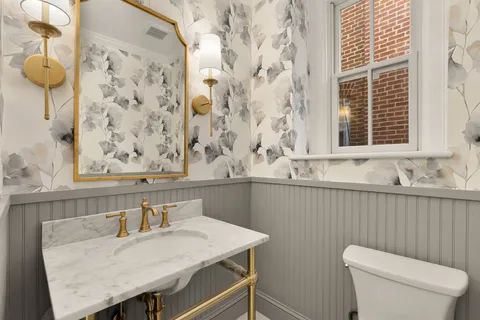 a bathroom with a granite countertop sink and a toilet