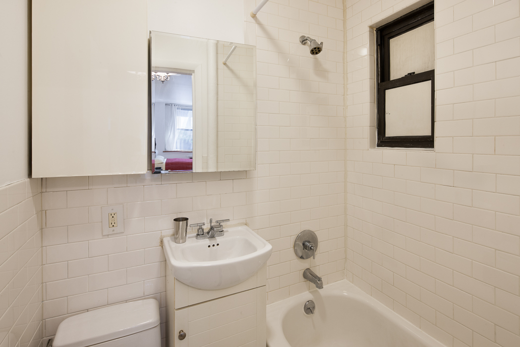 237 East 88th Street, Unit 103 Manhattan, NY 10128 - Photo 3 of 3 a bathroom with a sink a toilet and shower