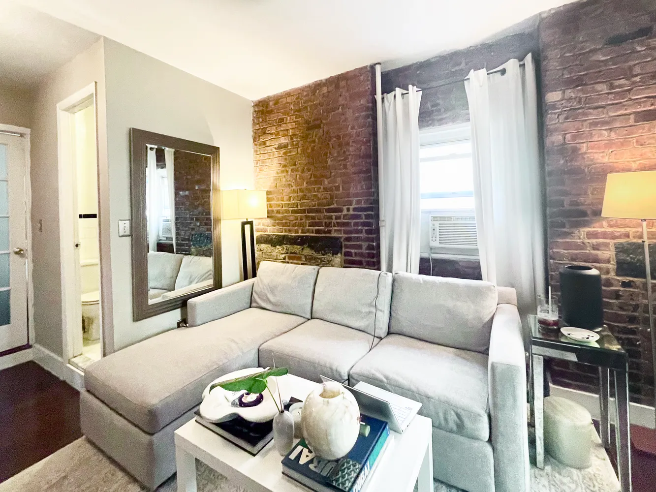 a living room with furniture and a floor to ceiling window