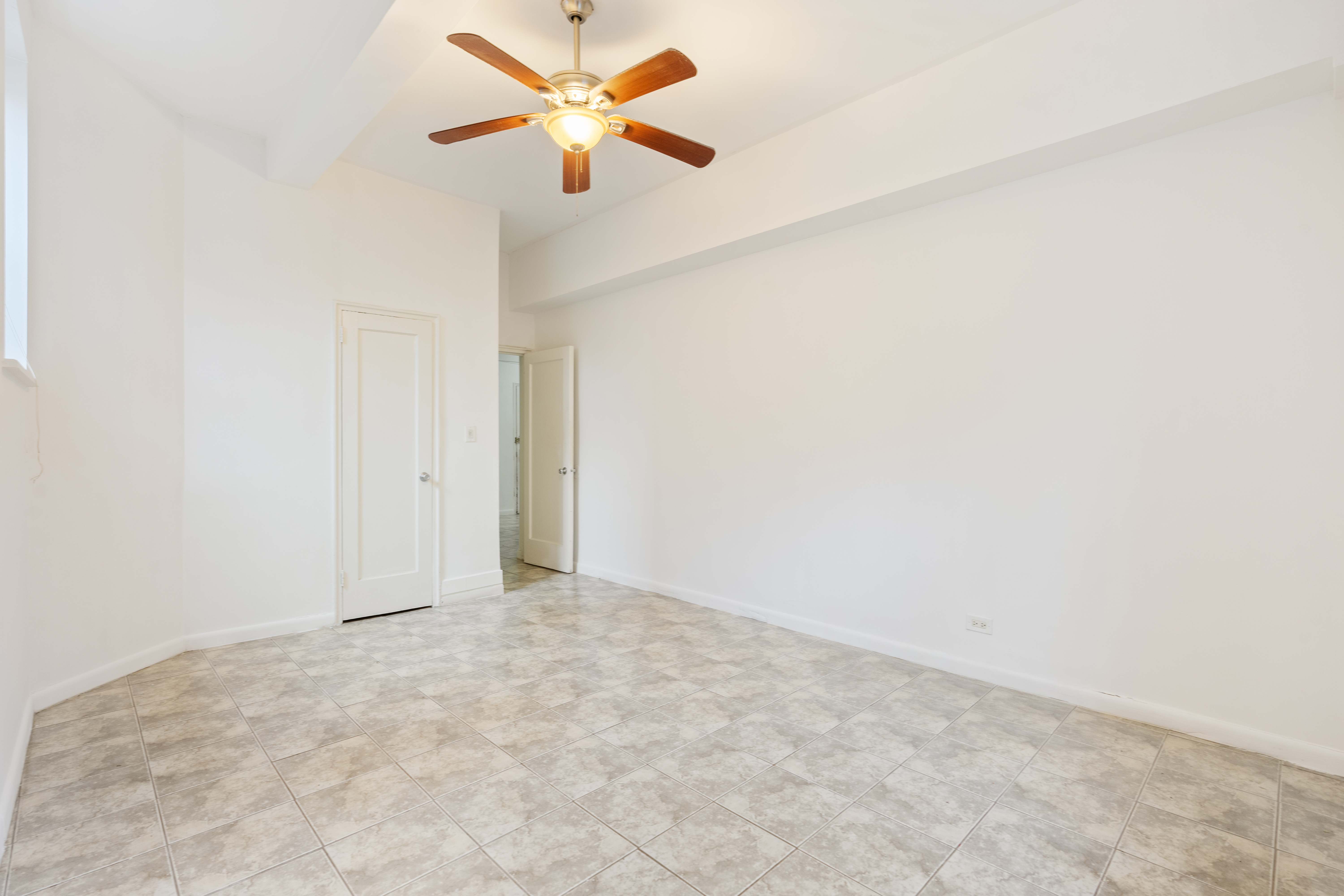 68-63 108th Street, Unit 1B Queens, NY 11375 - Photo 4 of 13 an empty room with a window and a fan