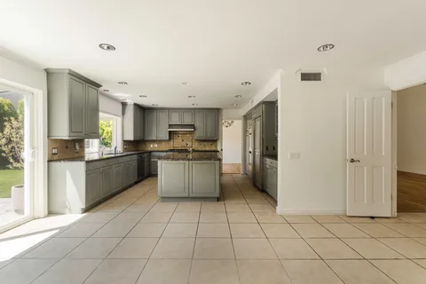 a large kitchen with a white cabinets and refrigerator