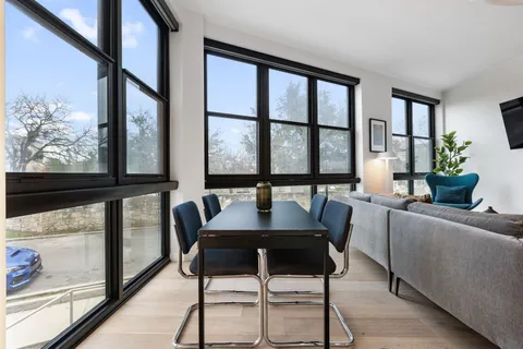 a view of a dining room with furniture large windows and wooden floor
