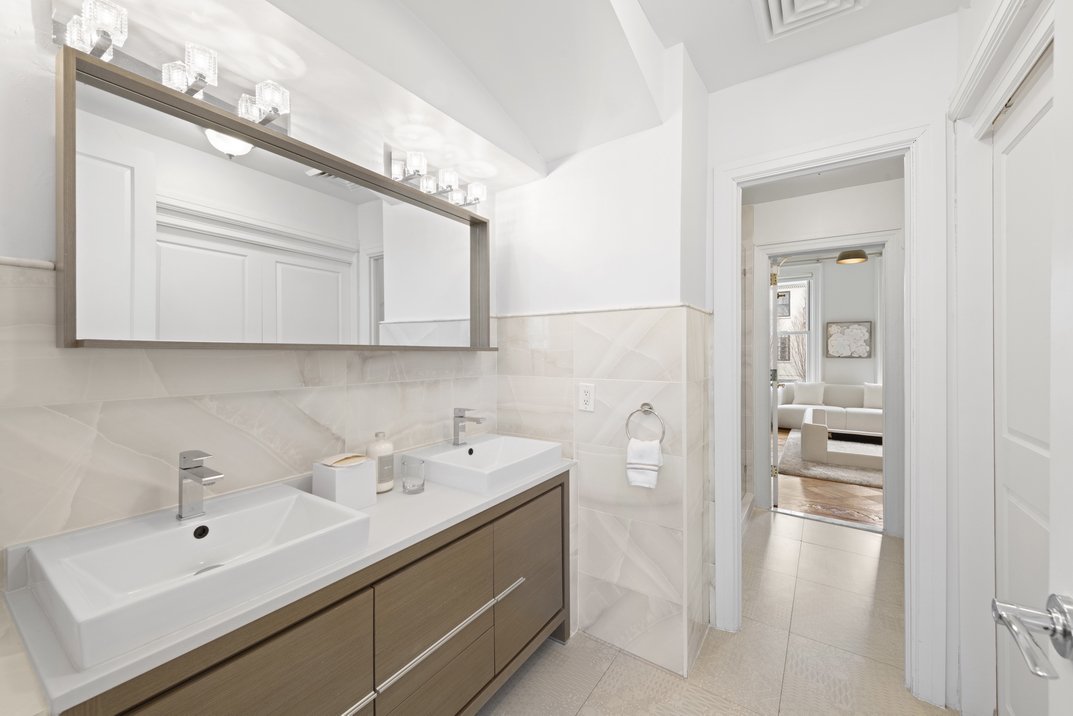 209 East 61st Street Manhattan, NY 10065 - Photo 13 of 27 a bathroom with a sink and a mirror