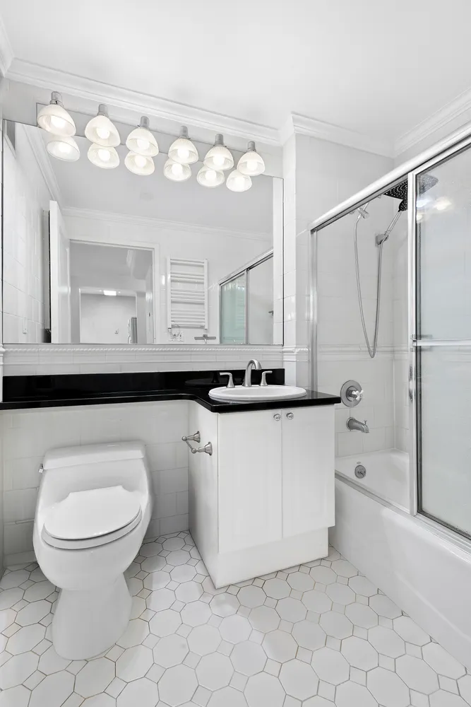 a bathroom with a sink a toilet and a mirror