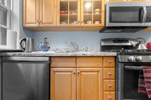 a kitchen with granite countertop a sink and a stove
