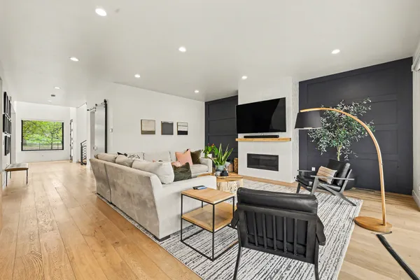 a living room with furniture a flat screen tv and a fireplace