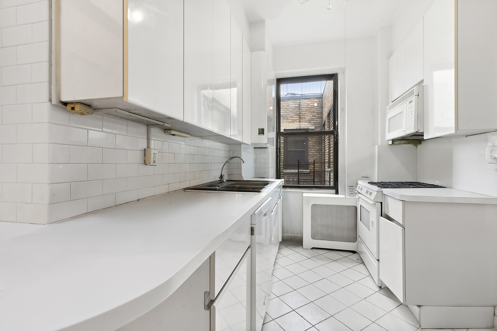 215 West 92nd Street, Unit 15A Manhattan, NY 10025 - Photo 6 of 14 a kitchen with a sink and cabinets