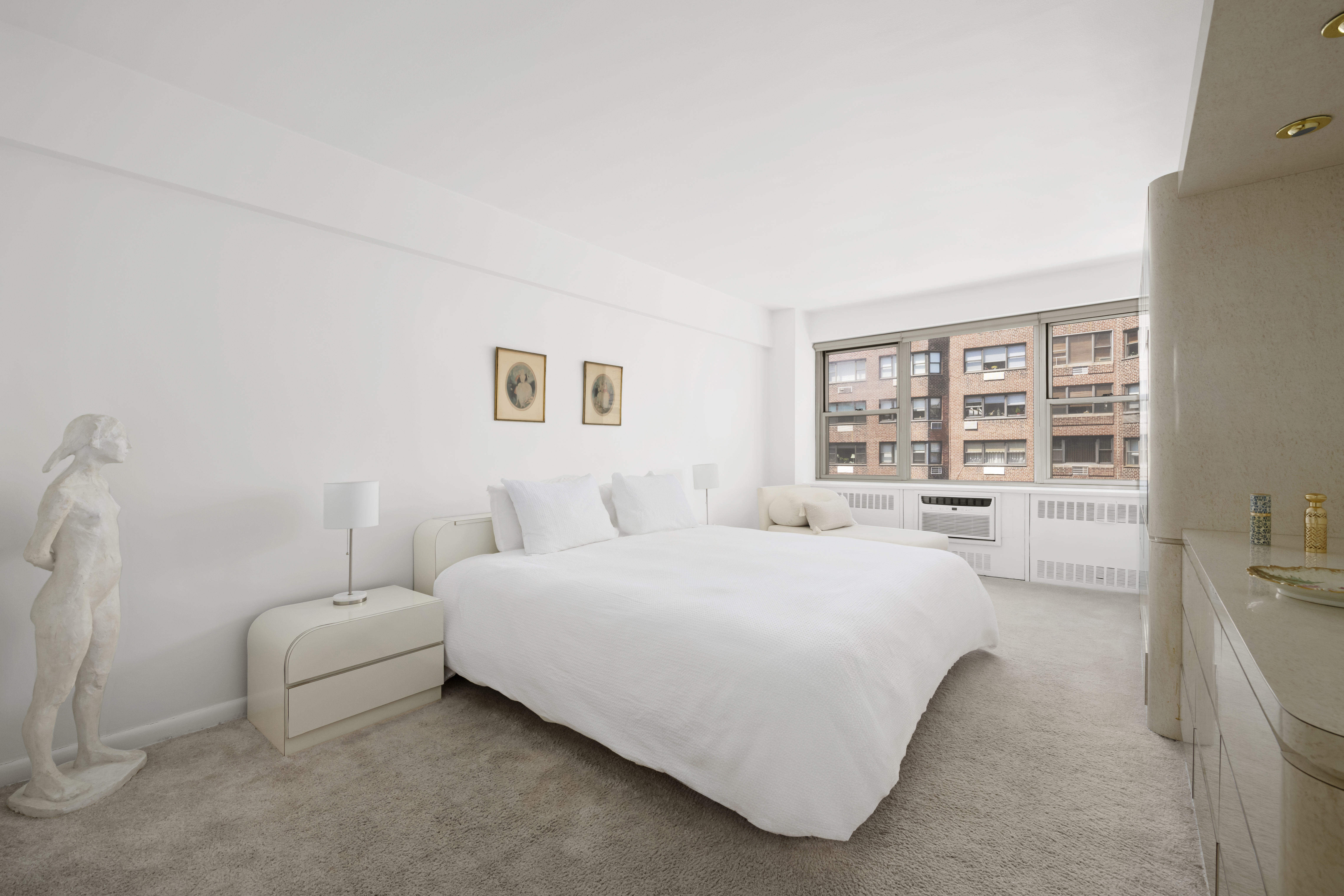 25 Sutton Place South, Unit 16B Manhattan, NY 10022 - Photo 8 of 16 a bedroom with a bed lamp and a large window