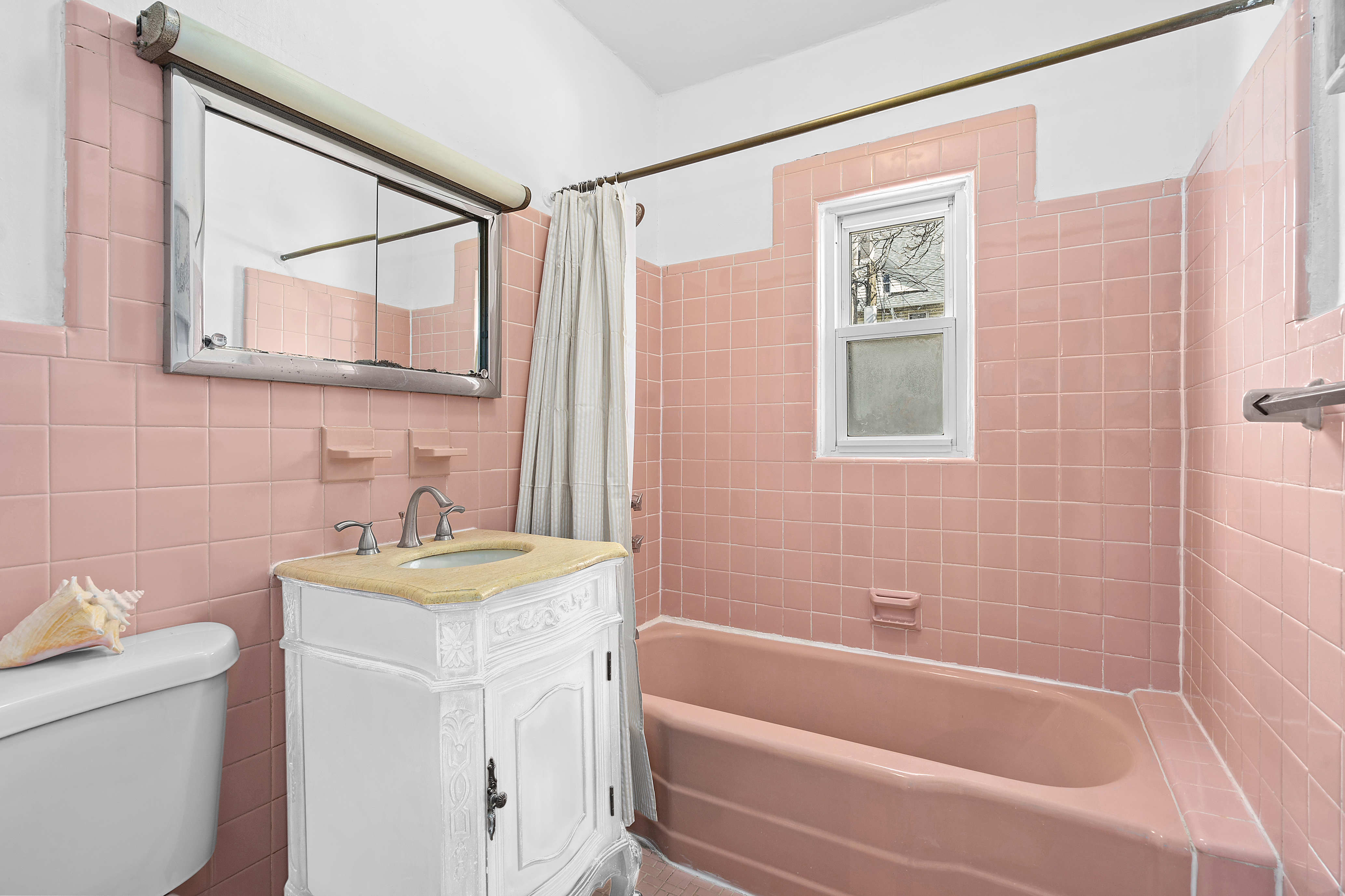 825 East 21st Street Brooklyn, NY 11210 - Photo 17 of 22 a bathroom with a sink a toilet a mirror a vanity a bath tub and shower