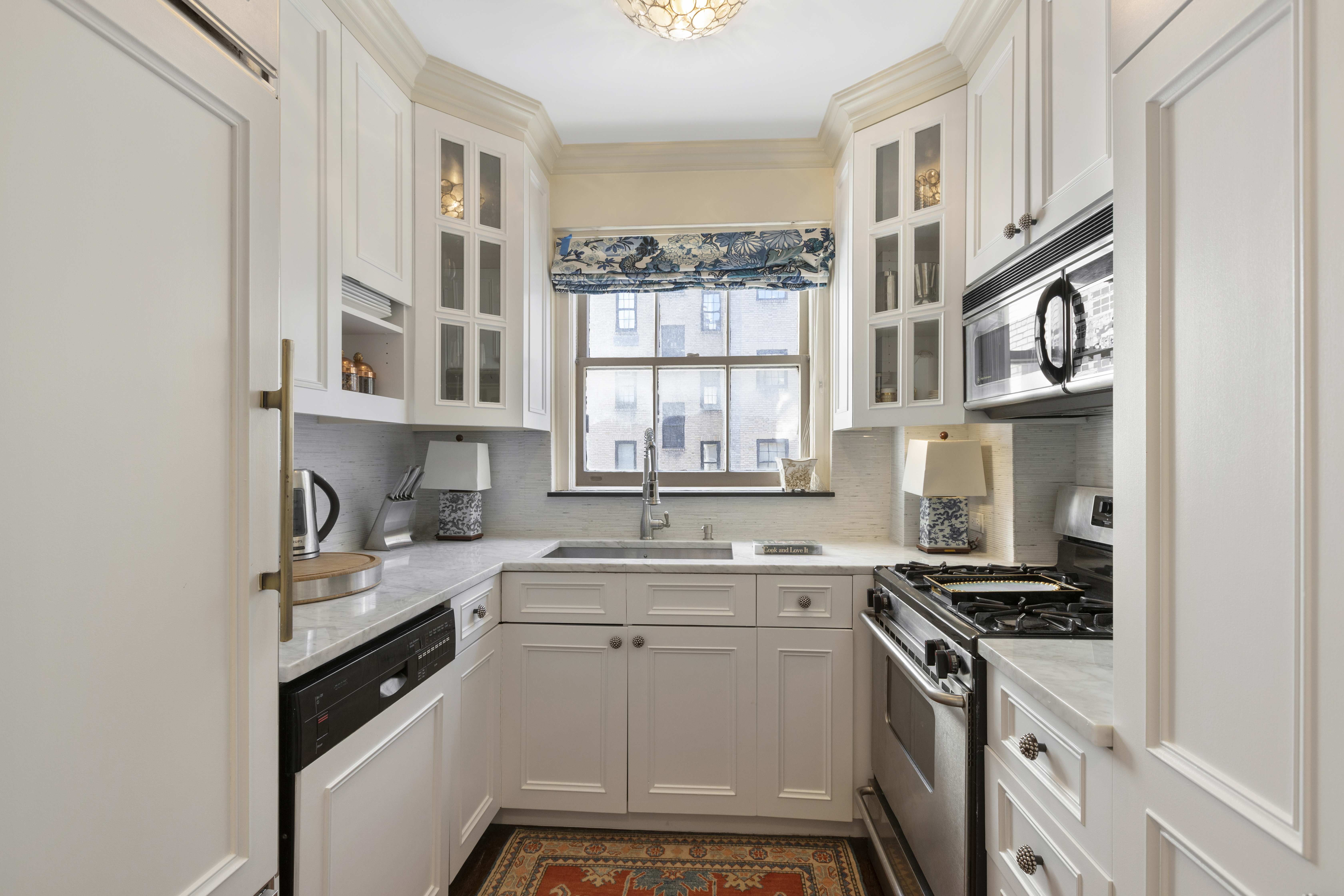 71 East 77th Street, Unit 9C Manhattan, NY 10075 - Photo 5 of 14 a kitchen with a sink stove and cabinets
