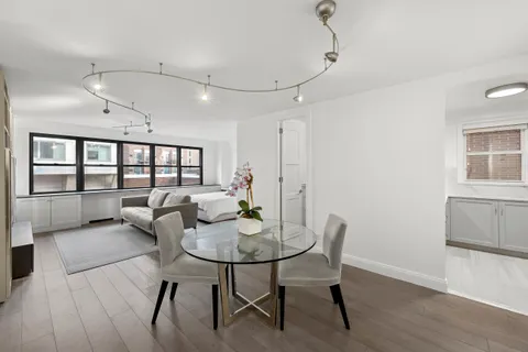 a view of a livingroom and a dining room with furniture window and wooden floor
