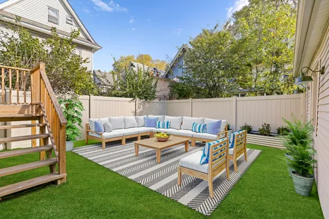 a view of a patio with table and chairs with wooden fence and plants