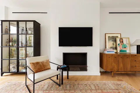 a living room with furniture a flat screen tv and a fireplace