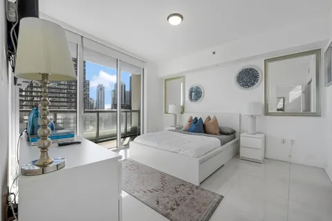 a bedroom with a large bed and a painting on the wall