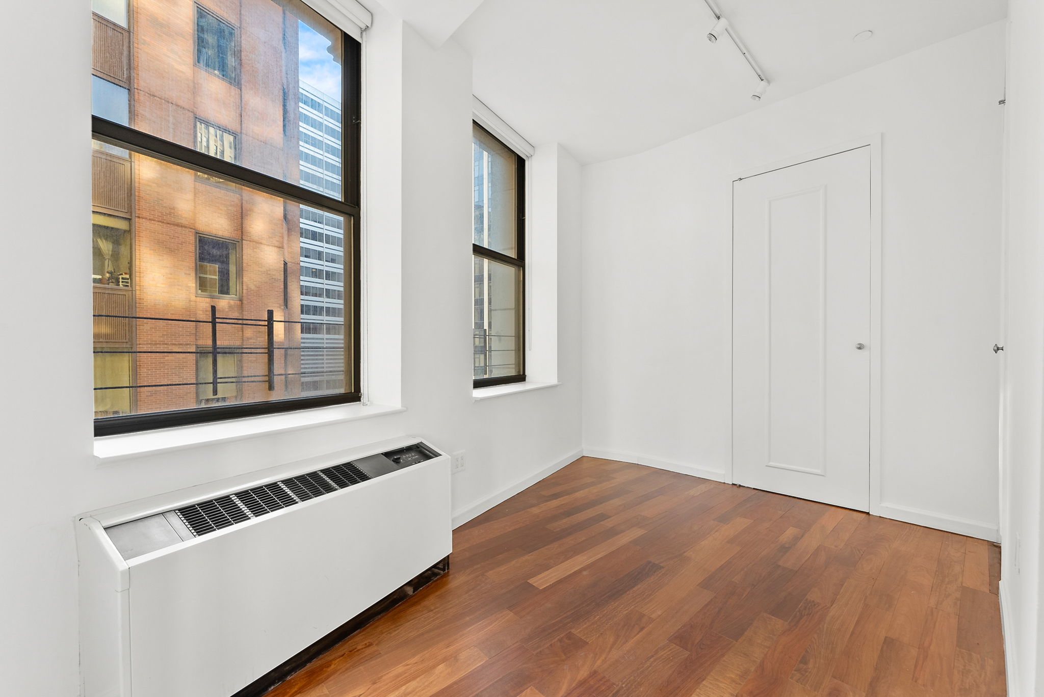 1 Wall Street Court, Unit 1405 Manhattan, NY 10005 - Photo 15 of 19 a room with a bed and a window