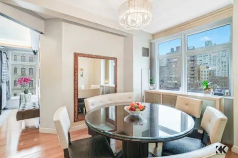 a dining room with furniture a chandelier and wooden floor