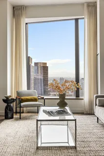 a living room with furniture and a floor to ceiling window
